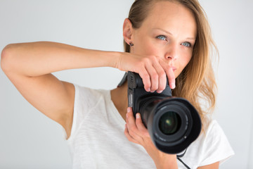 Pretty, female photographer with digital camera - DSLR and a hug