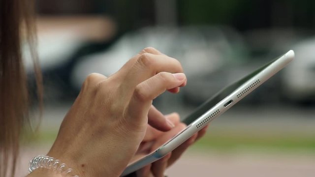Women's hands with the white tablet. Using a touchscreen tablet, slow