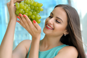 Girl holding a large bunch of ripe green grapes