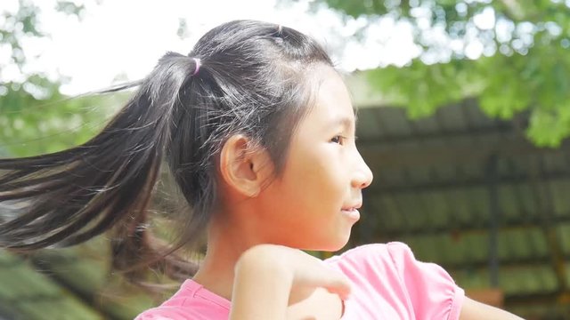 Asian Girl flips hair outdoor with funny face