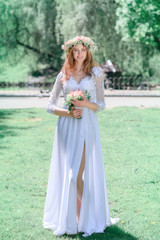 Fototapeta na wymiar Portrait of beautiful bride with flower wreath outside