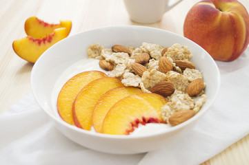 Whole grain cereal with fresh peach fruit, yogurt and almond in