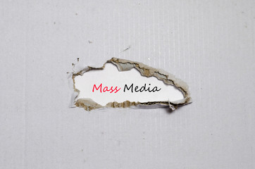 The word mass media appearing behind torn paper