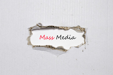 The word mass media appearing behind torn paper
