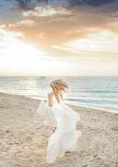 Fototapeta na wymiar Beautiful stylish girl posing in sunlight on the beach