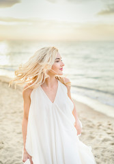 Fototapeta na wymiar Beautiful stylish girl posing in sunlight on the beach