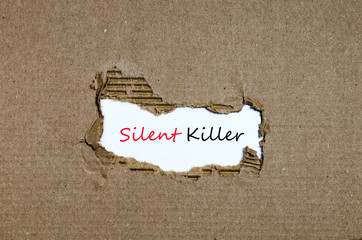 The word silent killer appearing behind torn paper