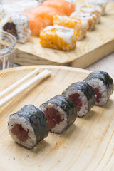 Different Sushi rolls,wasabi and ginger on a plate on wooden bac