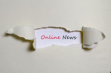 The word online news appearing behind torn paper
