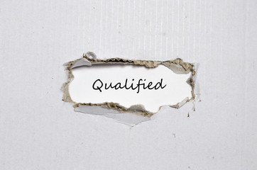The word qualified appearing behind torn paper