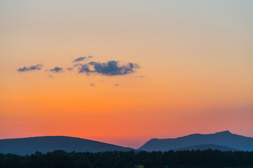 hill silhouettes under an orange sky