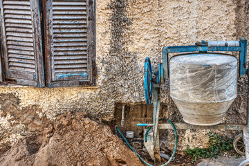 cement mixer by a rustic wall in Sardinia