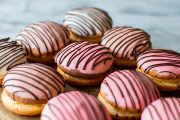 Cookie sandwiches with pink icing. Biscuits decorated by chocolate. Appetizing bush cakes. Sweet treats at local cafe.