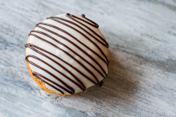 Biscuit with white icing. Cookie on gray wooden background. Decorated bush cake. Top view of fresh pastry.