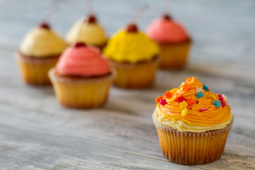 Cupcake with orange frosting. Small decorated dessert. Food that lifts mood. Simple recipe and refined taste.