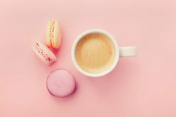 Keuken spatwand met foto Cup of coffee with macaron on pink background from above, flat lay © juliasudnitskaya