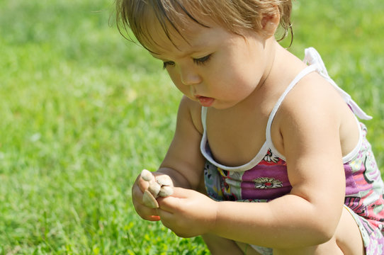 Little child playing with toxic toadstool mushrooms