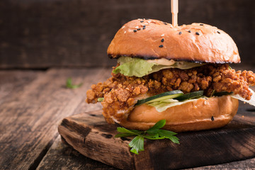 Tasty grilled burger with lettuce and mayonnaise ,on a rustic wooden table