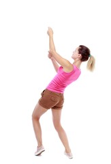 back view of standing girl pulling a rope from the top or cling to something. Isolated over white background. Sport blond in brown shorts pulls the rope from above.