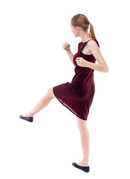 skinny woman funny fights waving his arms and legs. Isolated over white. girl in a burgundy dress has foot.