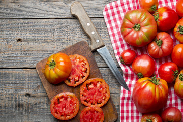 Dojrzałe organiczne pomidory na drewnianym tle