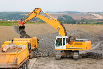 Fototapeta na wymiar Motorway under Construction, Excavator and Dump trucks at Work