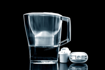 White water filter jug with spare filters on black background.