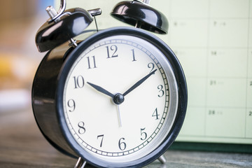 alarm clock and calendar on wooden table