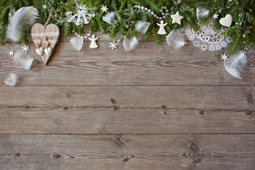 Fototapeta na wymiar Christmas wooden background with fir branches, lace, feathers and angels