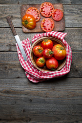 Dojrzałe organiczne pomidory na drewnianym tle