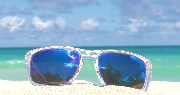 Sunglasses on the tropical beach. Travel relax vacation - azure sea, white sand, shining sun,