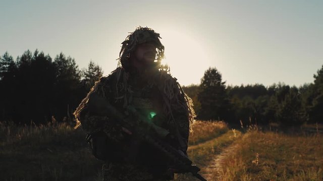 Steadicam shot: Armed with a man walking on a country road at sunset