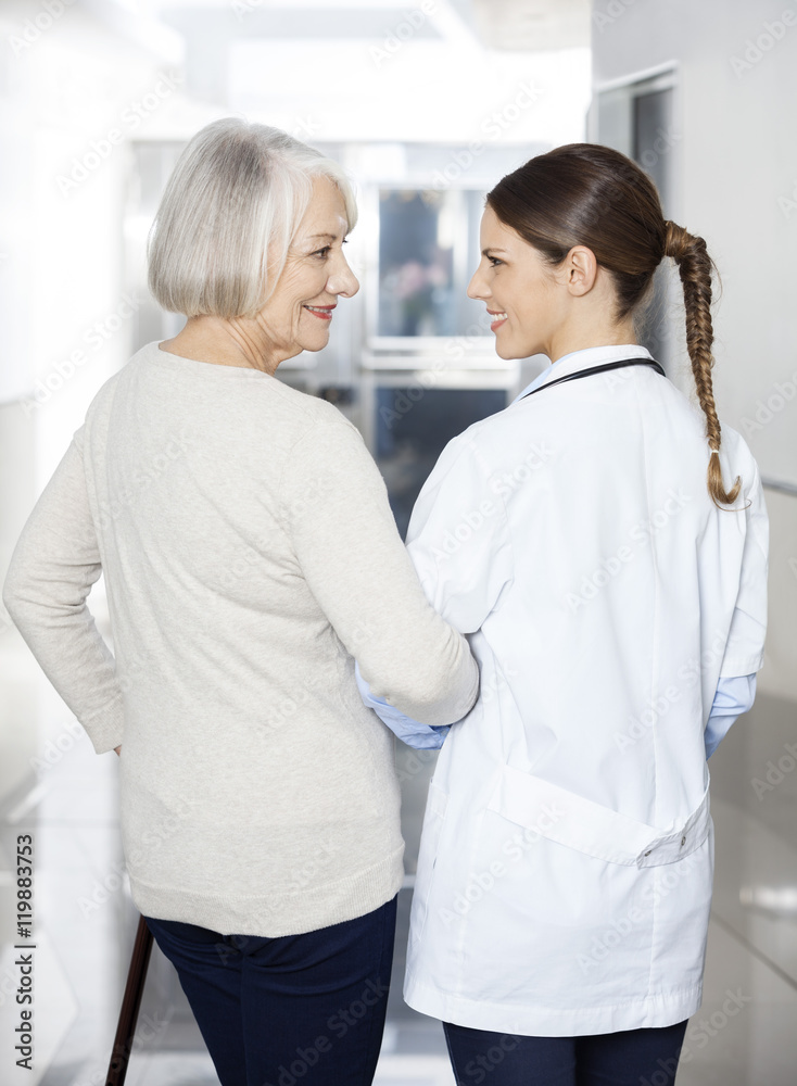 Wall mural Disabled Senior Patient Standing With Physiotherapist At Rehab C