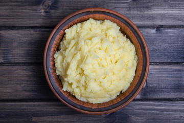 Mashed potatoes in a plate on the wooden table