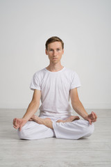 Young man meditating in Lotus position on the floor