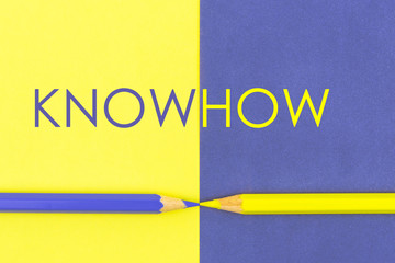 KnowHow concept with Yellow and Violet coloured pencils and paper.