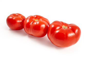 A tomato. Red tomato on a white background. Harvest vegetables. Autumn harvest. Red, juicy, ripe tomato.