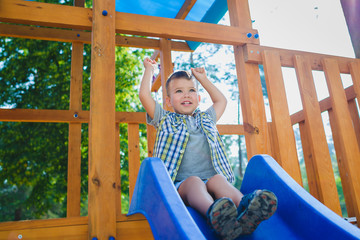 Obraz premium Smiling kid having fun at playground. Child playing outdoors