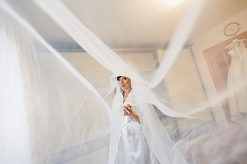Beautiful bride is standing and posing at home