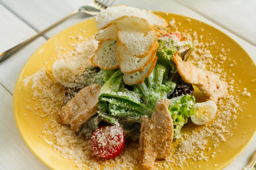Restaurant food closeup. Caesar chicken salad with parmesan