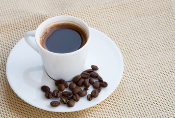 Cup of aromatic espresso black coffee and  beans