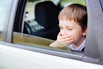 Child suffers from motion sickness in car - obrazy, fototapety, plakaty