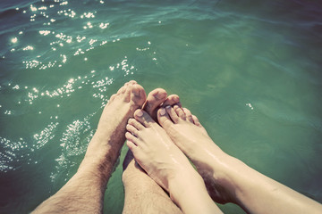 A couple in love wetting their feet in the sea. Summer holidays. Vintage.