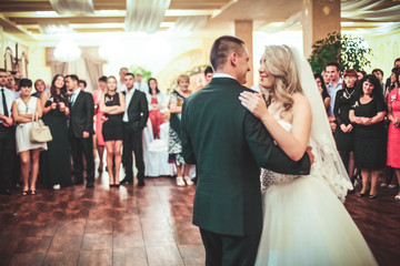 Happy bride and groom dancing alone on the dance floor their first wedding dance.