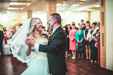 Happy bride and groom dancing alone on the dance floor their first wedding dance.