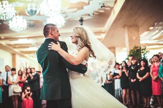 Happy bride and groom dancing alone on the dance floor their first wedding dance.