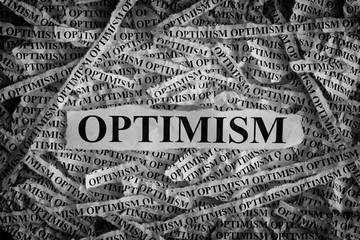 Torn pieces of paper with the word Optimism