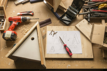 build birdhouse, wood, screws and tools lying on the bench