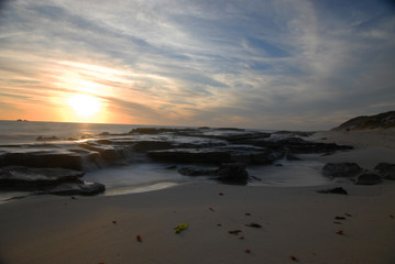 Fototapeta na wymiar Sunset with water over rocks