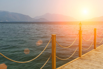Obraz premium Wooden pier on a background of the sea landscape and mountains.